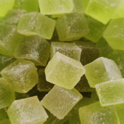 Vackert grön, handgjord, äppelmarmelad, skuren i kuber och rullade i fint socker.